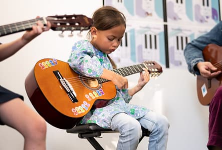 Guitar Sienna concentraing looking down Guitar